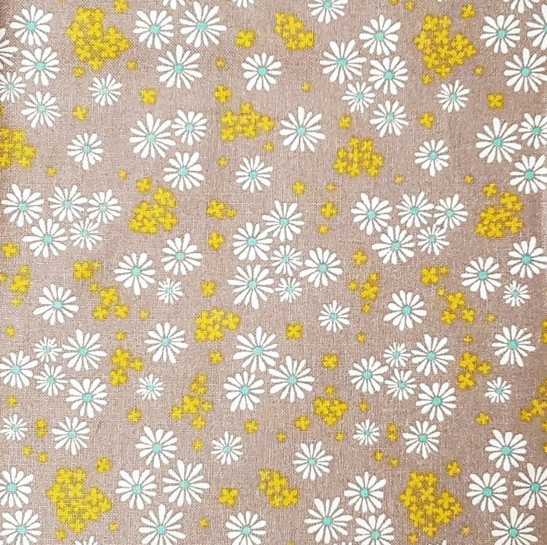 May include: A brown fabric with a white and light blue daisy pattern and small yellow flower accents.
