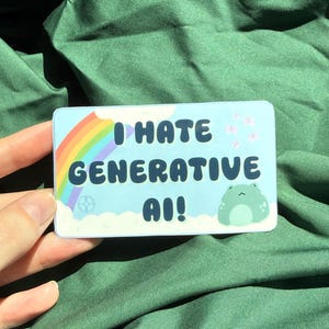 May include: A rectangular sticker with a light blue background featuring the text I HATE GENERATIVE AI! in dark blue letters. The design includes a colourful rainbow on the left, small pink flowers on the right, and a light green frog illustration.
