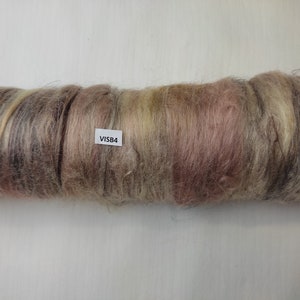 May include: A roll of brown, beige, and pink wool roving with a white label that says "VISB4".