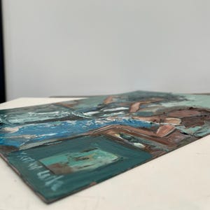 May include: An abstract painting with thick brushstrokes. The artwork features a palette of blues, greens, and browns, creating a textured surface. The composition includes rectangular and organic shapes, suggesting a landscape or interior scene.