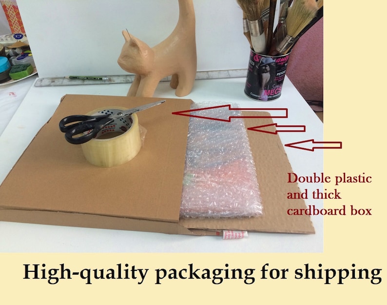 May include: A cardboard box with bubble wrap and tape, ready for shipping. Scissors and a roll of tape sit on top of the box. The packaging is designed to protect the contents during transit.