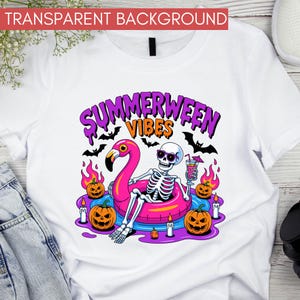 May include: White t-shirt with a colorful graphic featuring a skeleton in sunglasses relaxing on a pink flamingo float. The design includes pumpkins, bats, flames, and the text "Summerween Vibes".
