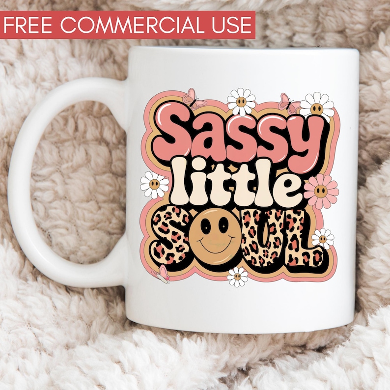 Puede incluir: Taza de cer&aacute;mica blanca con un dise&ntilde;o gr&aacute;fico rosa, amarillo y marr&oacute;n. El dise&ntilde;o presenta el texto "Sassy little soul" en una fuente retro con una carita sonriente y estampado de leopardo.