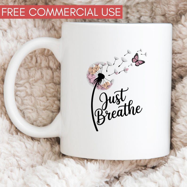 Może przedstawiać: Biały ceramiczny kubek z motywem dmuchawca z r&oacute;żowymi i beżowymi płatkami oraz motylem. Napis "Just Breathe" jest napisany kursywą. Kubek ma zakrzywiony uchwyt.