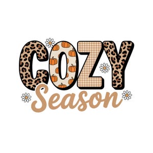 以下が含まれることがあります： 秋をテーマにした「COZY Season」のグラフィックデザイン。文字の「C」と「Y」はヒョウ柄、「O」はカボチャで埋められ、「Z」はチェック柄。テキストの周りには、小さなデイジーの花が散りばめられています。
