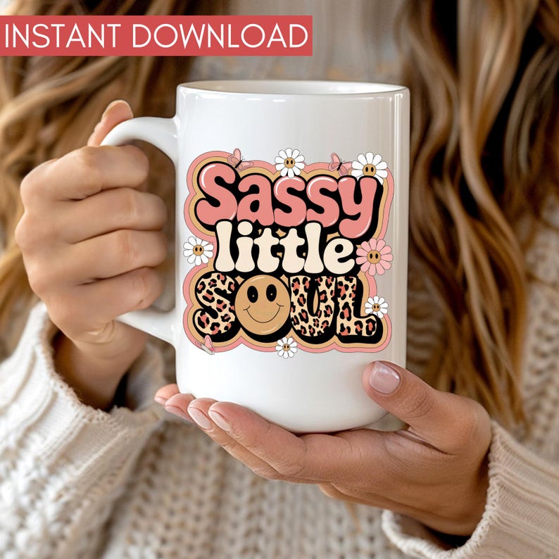 Puede incluir: Taza de cer&aacute;mica blanca con un dise&ntilde;o gr&aacute;fico rosa y marr&oacute;n que dice "Sassy little soul" con una cara sonriente y estampado de leopardo.