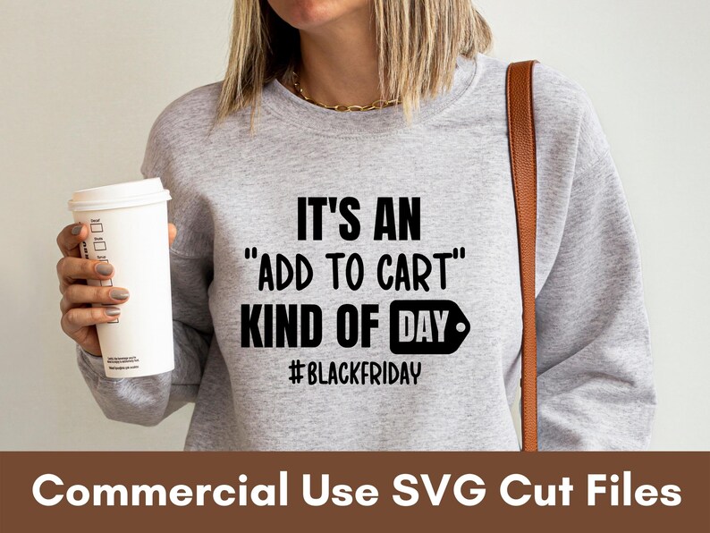 Puede incluir: Una sudadera gris claro con el texto "IT'S AN 'ADD TO CART' KIND OF DAY #BLACKFRIDAY" en negro. Una taza de caf&eacute; blanca se sostiene en la mano izquierda. Las palabras "Commercial Use SVG Cut Files" est&aacute;n en la parte inferior.