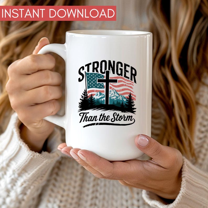 May include: White ceramic mug with a black and red design featuring a cross and an American flag. The text "Stronger Than the Storm" is printed on the mug.