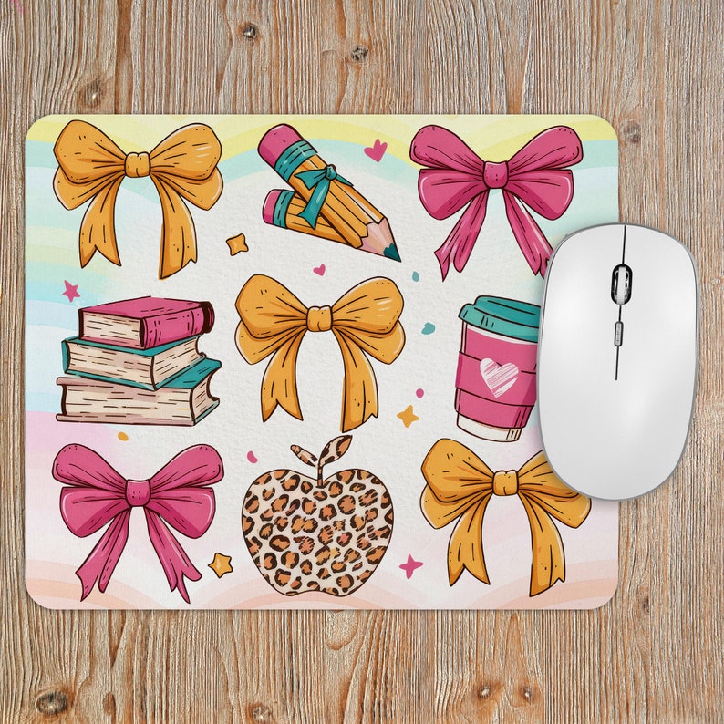 May include: A colorful mousepad with a variety of illustrations, including books, pencils, bows, a coffee cup, and an apple. The mousepad has a light yellow background with a rainbow pattern.