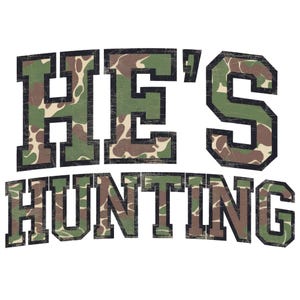 May include: A camouflage print graphic with the text "HE'S HUNTING" in black letters.