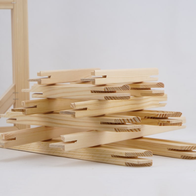 May include: A stack of wooden canvas stretcher bars, ready to be assembled into a frame for a painting or artwork.