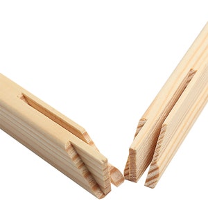 May include: Close-up of two wooden stretcher bars for a canvas, showing the interlocking joinery. The bars are made of natural, light-colored wood.