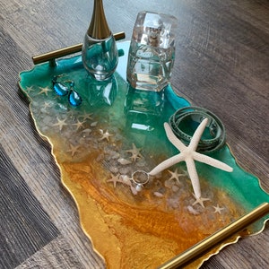 love the tropical ocean you will love this  Elegant Resin ocean tray with sea star /gold flakes  and gold handles . Dimensions are 14 by 8 .