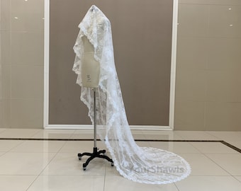 May include: A white lace bridal veil with a scalloped edge. The veil is displayed on a mannequin and is approximately 254 cm long.