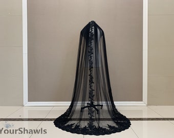 May include: Black tulle veil with a black lace trim. The veil is displayed on a mannequin.