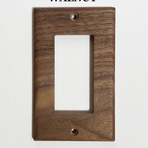 May include: Walnut wood light switch cover plate with a single switch opening and two screw holes.
