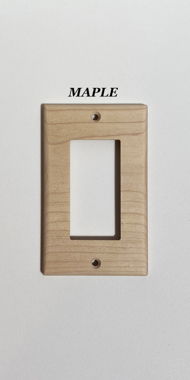 May include: A light wood wall plate with a single rectangular opening and two small holes. The plate is labeled "MAPLE".