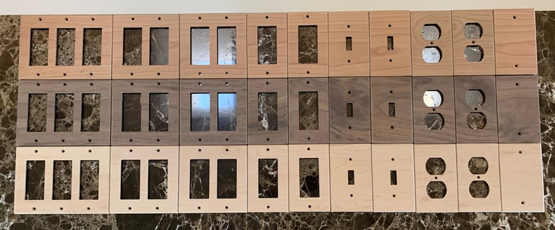 May include: A set of 30 wooden wall plates in various wood tones, including light and dark wood. The plates are designed for electrical outlets and light switches. Some plates have single openings, while others have double openings.