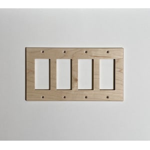 May include: A natural wood wall plate with four cutouts for electrical switches. The plate has eight screw holes for mounting.