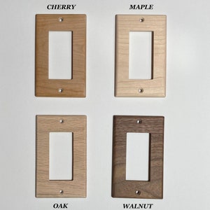 May include: Four wooden light switch plates in different wood finishes: cherry, maple, oak, and walnut.