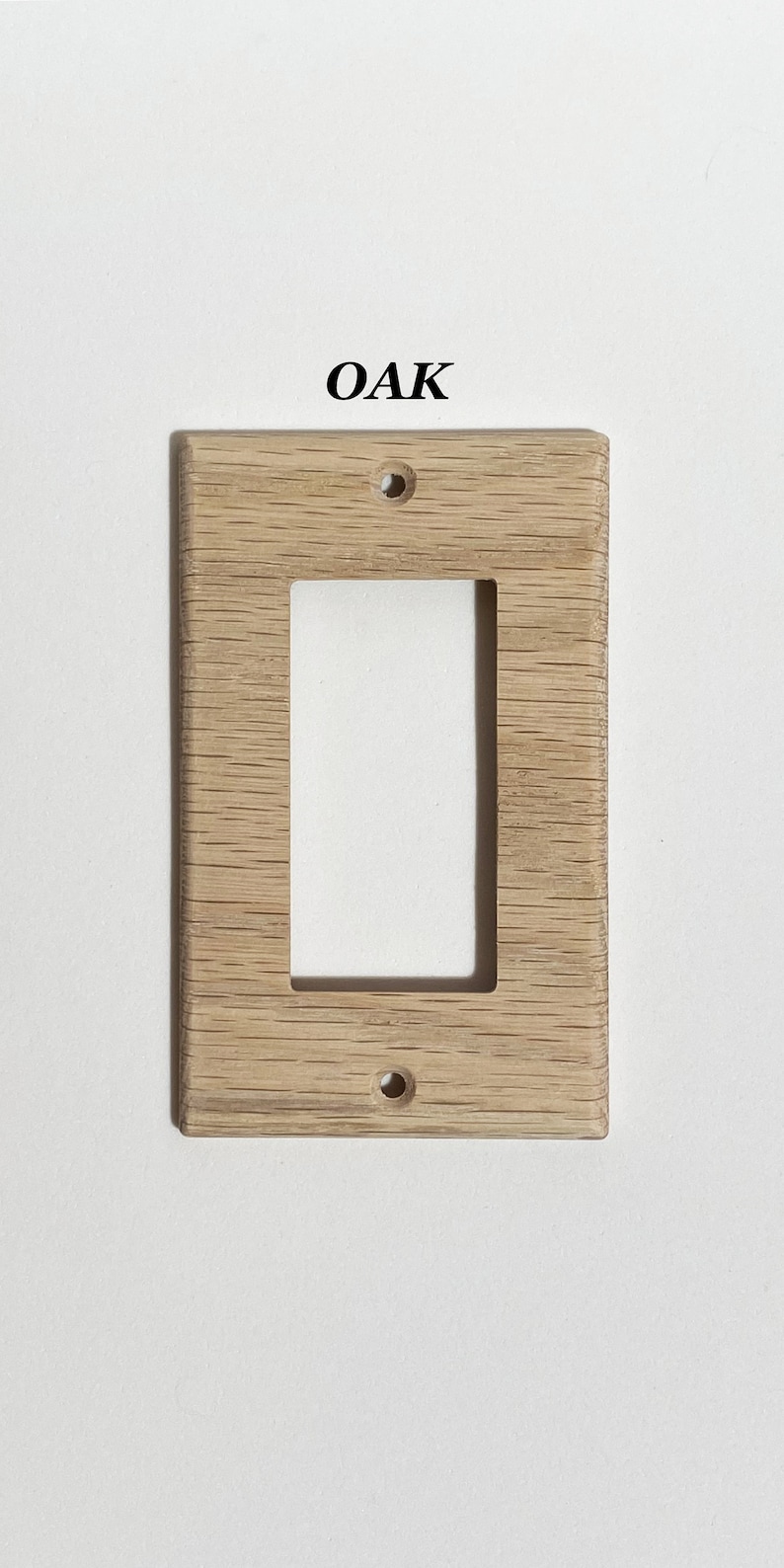 May include: A light wood wall plate with a rectangular cutout for a light switch. The plate is labeled "OAK".