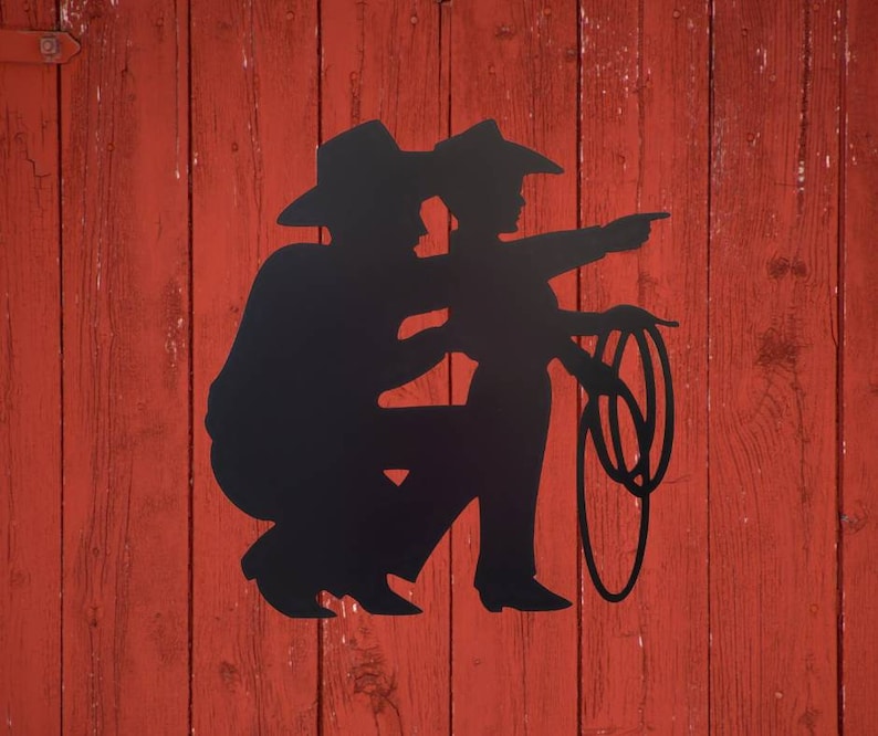 Cowboy and Son Metal Sign is hanging on a wall.