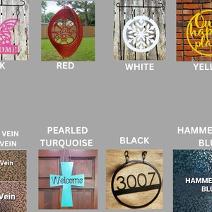May include: A collection of decorative metal signs in various colors and designs. Includes a pink butterfly with "WELCOME", a red spiral, a white snowflake, and a yellow sign with "Our happy place". Also shown are metal textures and a turquoise cross.