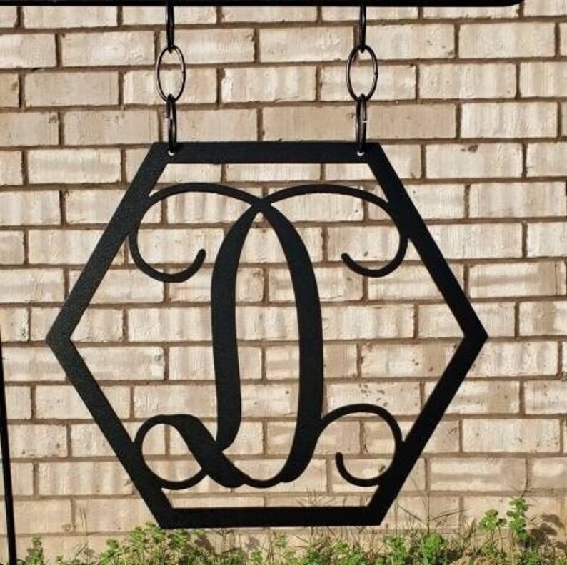 Initial Metal Garden flag. It has a hexagon shape with the swirl monogram initial in the middle. This garden flag is powder coated so it is weather resistant.