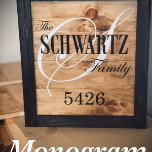 May include: Wooden family name sign with a black frame. The sign features the name "SCHWARTZ Family" in a stylish font, with the address "5426" below. The word "Monogram" is at the bottom.