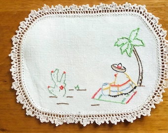Tapete rectangular pequeño bordado a mano con motivos mexicanos.
