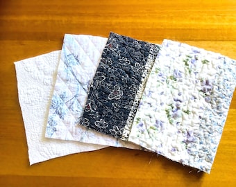 4 piezas de patchwork para manualidades en tonos azules, malvas y blancos.