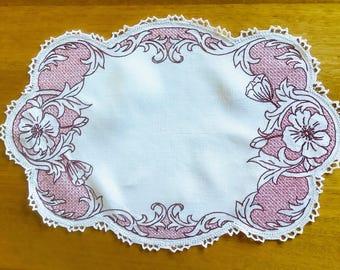 Tapete rectangular bordado a mano con punto de cruz rosa y marrón.