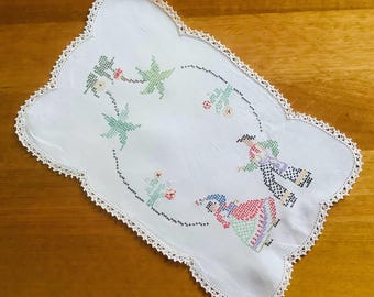 Tapete rectangular bordado a mano con flores verdes.