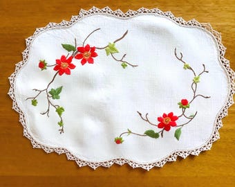 Tapete rectangular bordado a mano con diseño floral.