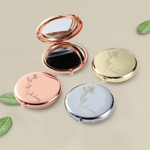 May include: Three compact mirrors with personalised engravings. The mirrors are in rose gold, silver, and gold. Each mirror features a floral design and a name: Aubrey, Lana, and Lana.