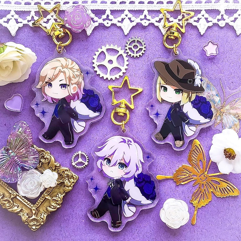 Op de afbeelding: Drie anime-personagecharms met paarse bloemen en gouden steraccenten. De charms zijn gemaakt van helder acryl en bevatten gedetailleerde illustraties van de personages.