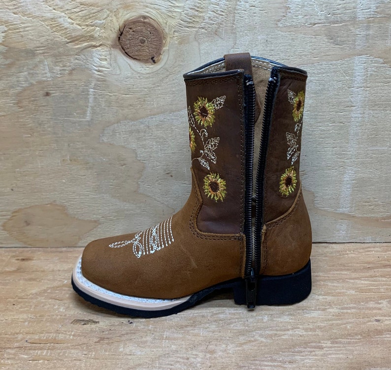 May include: Brown leather children's boots with a side zipper and sunflower embroidery.