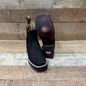 May include: Black leather ankle boots with a snakeskin pattern. The boots have a pointed toe and a pull-on design. The boots are made by La  Samba.