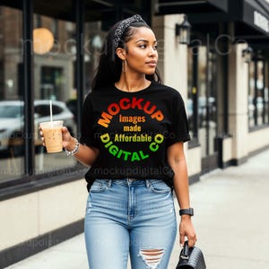 Puede incluir: Una persona lleva una camiseta negra con las palabras "MOCKUP Images made Affordable DIGITAL Co" en un diseño circular. Lleva vaqueros azules y una diadema negra, sosteniendo una bebida de café.