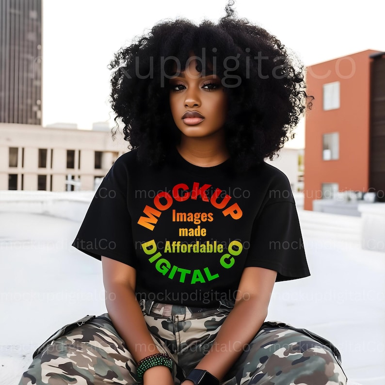 May include: A person wearing a black t-shirt with a colorful circular graphic that says "MOCKUP DIGITAL CO. Images made Affordable". The person is sitting on a concrete surface wearing camouflage pants.