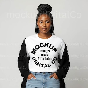 Puede incluir: Una mujer con una camiseta blanca con el texto "MOCKUP Images made Affordable DIGITAL CO" en un diseño circular negro. También lleva una rebeca negra y vaqueros azules.
