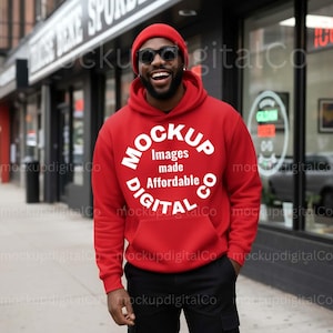 May include: A red hoodie with the text "MOCKUP Images made Affordable DIGITAL Co" in white. The person is wearing a red beanie and black sunglasses. The person is standing outside a store.
