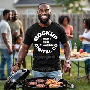 May include: A black t-shirt with the text "MOCKUP Images made Affordable DIGITAL CO" is worn by a person grilling food on a barbecue. The grill contains burgers and chicken. Other people are in the background.