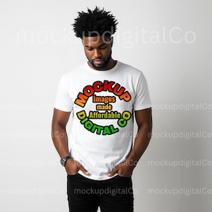 May include: A white t-shirt featuring a colorful circular design with the text "MOCKUP Images made Affordable DIGITAL". The design uses orange, green, and yellow colors. The person is wearing a black watch and black pants.