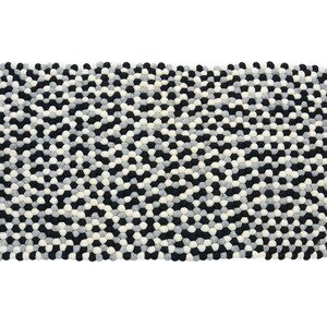May include: A black, white, and gray area rug made of felt balls. The rug has a geometric pattern.