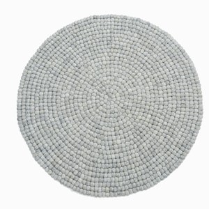 May include: A round, gray, wool rug made of small, densely packed balls. The rug is approximately 3 feet in diameter.