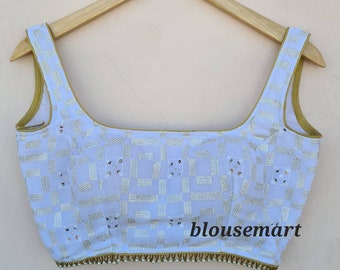 Puede incluir: Blusa blanca sin mangas con un patrón geométrico y ribete dorado. La blusa tiene un escote cuadrado y está decorada con pequeñas lentejuelas transparentes. El texto "blousemart" es visible en la esquina inferior derecha de la imagen.