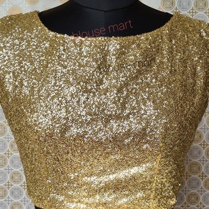 Puede incluir: Una blusa sin mangas de lentejuelas doradas con cuello de barco. La blusa está hecha de una tela suave y elástica y tiene un ajuste cómodo.