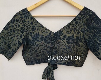 May include: A black and green patterned blouse with a tie at the front. The blouse has a V-neck and short sleeves. The text "blousemart" is visible on the front of the blouse.