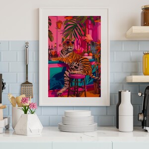 May include: Framed art print depicting a tiger in sunglasses at a bar with a tropical theme. The artwork uses vibrant colours, including pink, teal, and orange, and is surrounded by lush greenery.